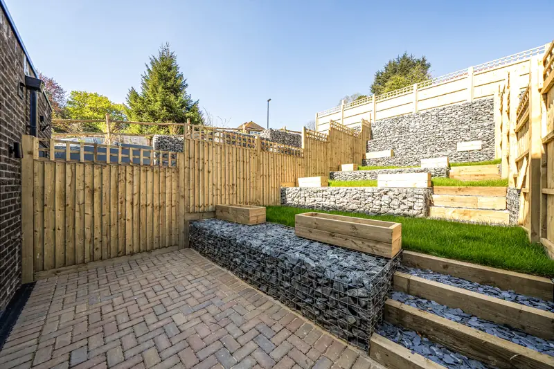 Tiered rear garden with gabion walls and planters